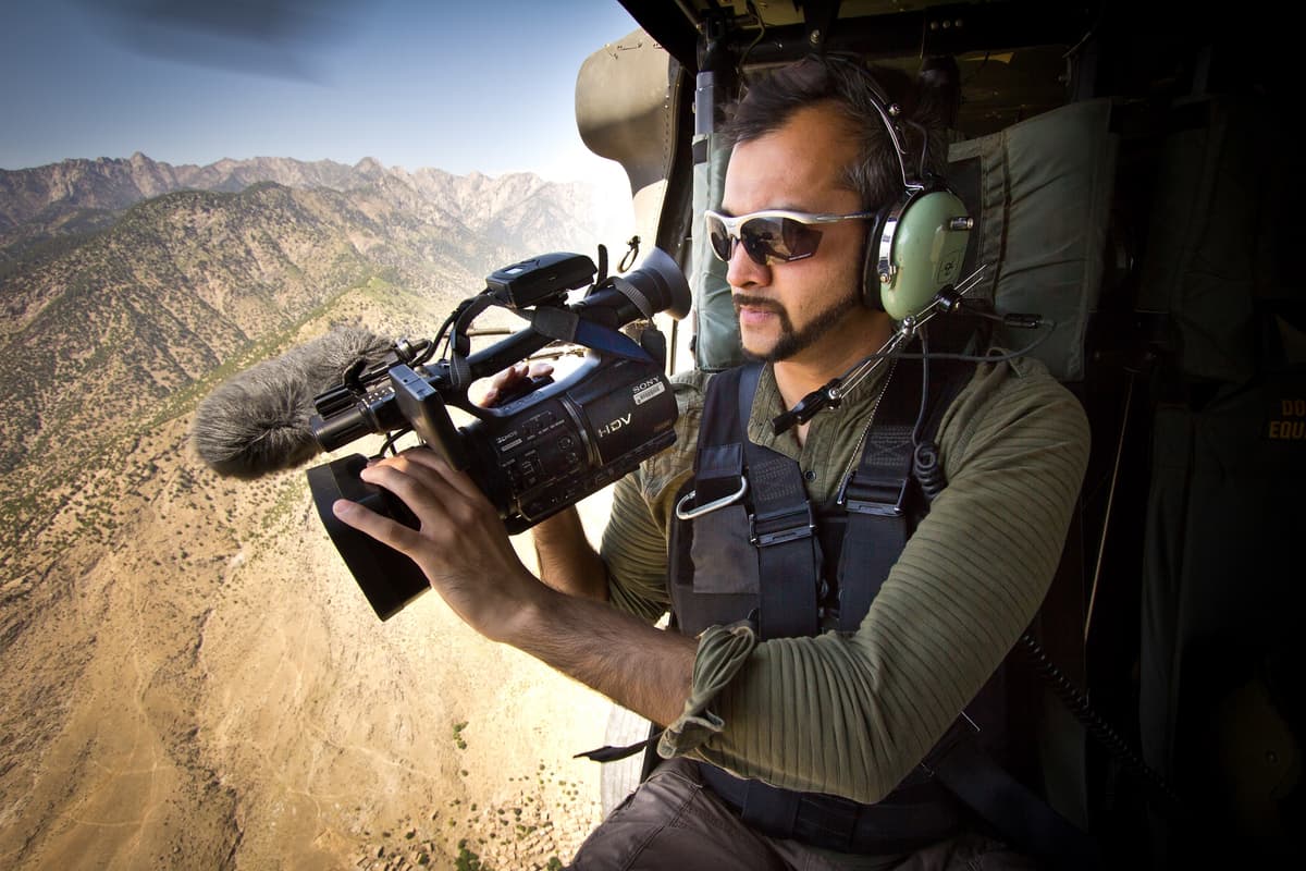 Muhammad Lila filming from a military helicopter in Afghanistan